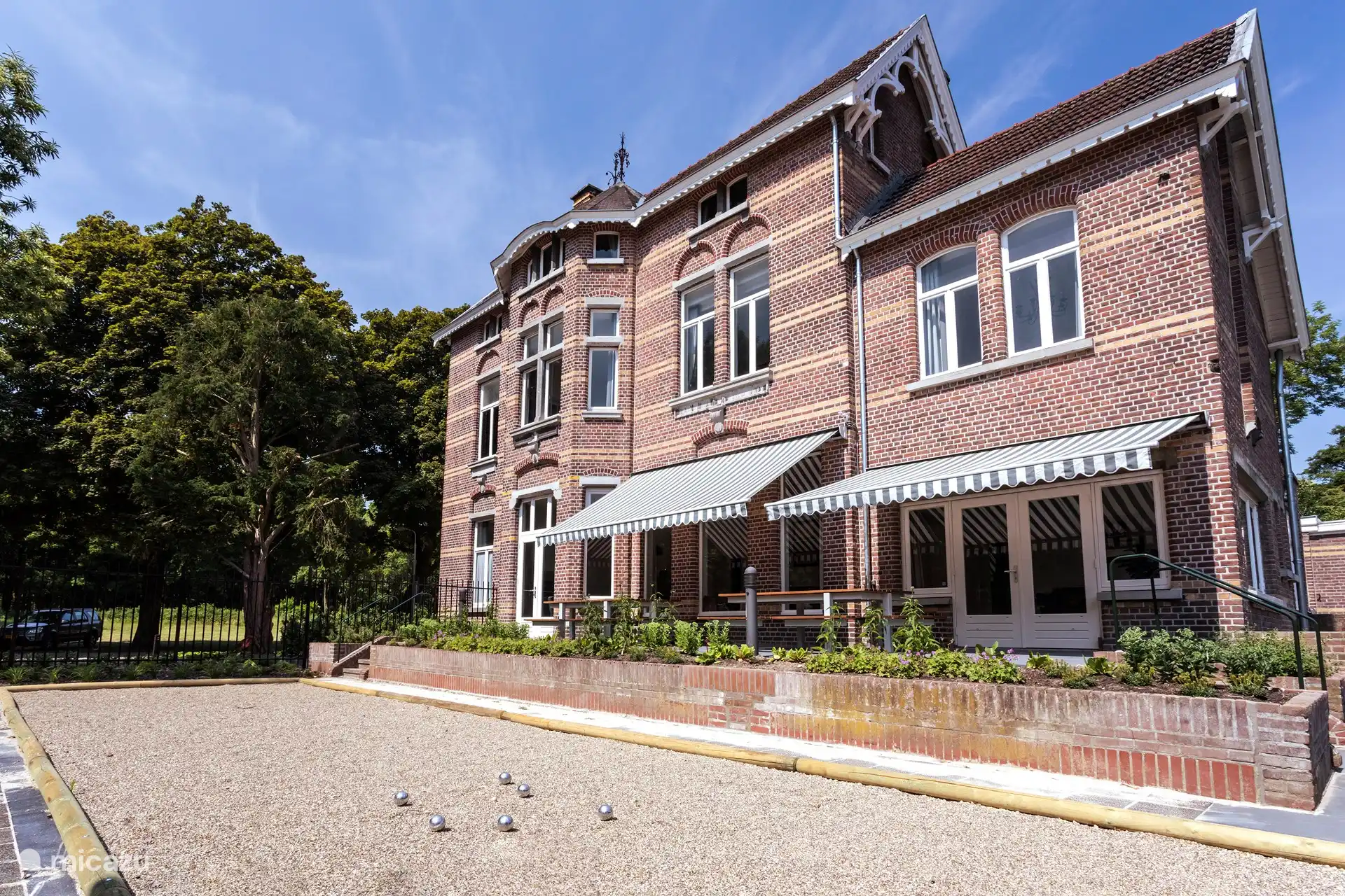 Die Terrasse an der Seite mit dem Bouleplatz. Auch eine Terrasse mit zwei großen Picknicktischen.