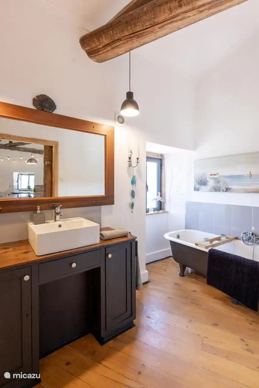 Bathroom with bathtub. Downstairs is an additional modern bathroom with mobile shower