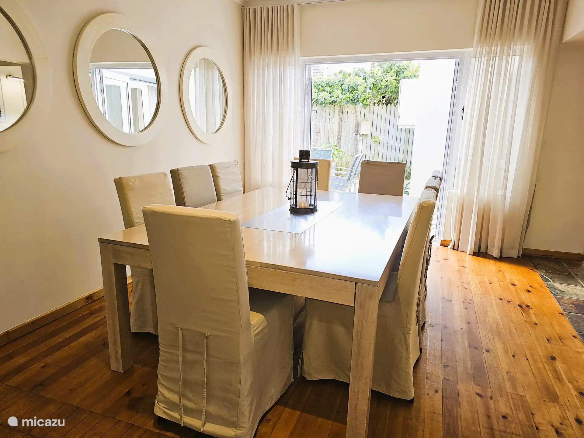 Dining table and patio doors to a terrace with outdoor seating and Weber braai