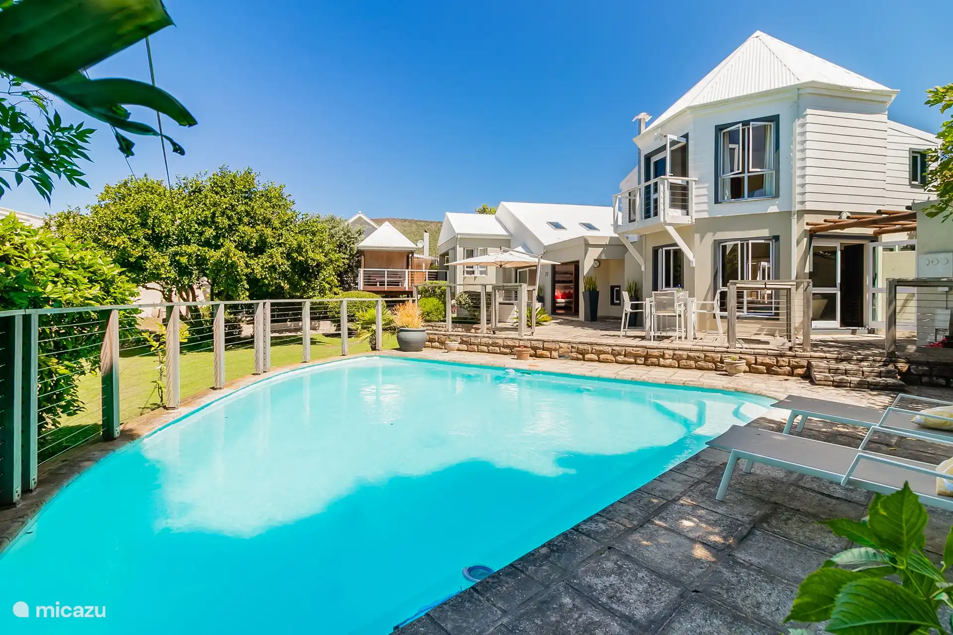 Large swimming pool (with child gate) with sunbeds