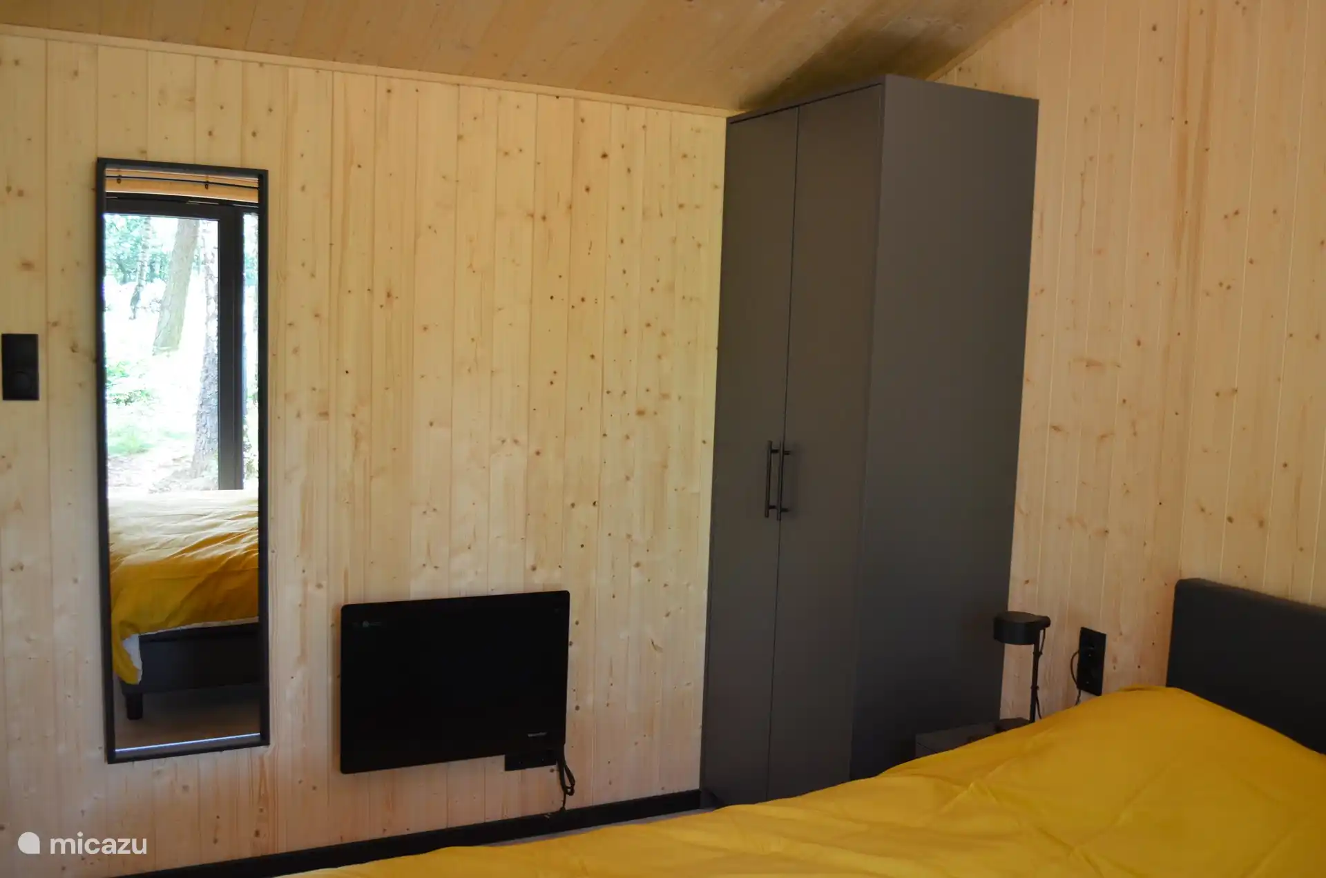 Es gibt einen Kleiderschrank, einen Spiegel und eine Heizung im Hauptschlafzimmer