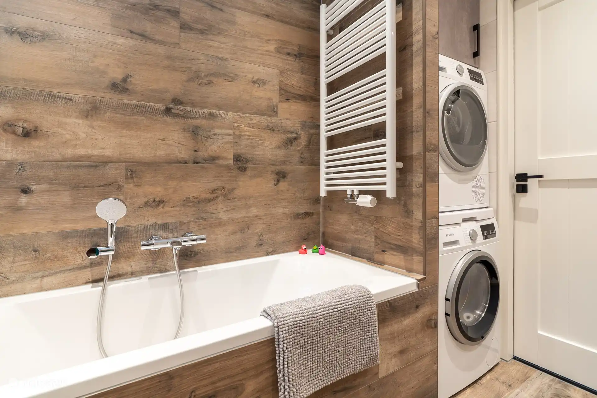 Geräumiges Badezimmer mit Badewanne, Dusche, Waschmaschine und Trockner. 