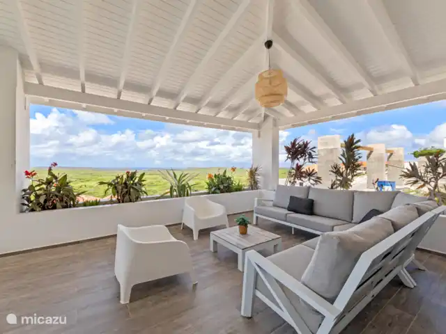 Villa Bista di Laman  en Curazao, Bandabou (oeste), Fontein - villa Moderno salón ambientado para relajarse después de un día de playa o aventura. El porche ofrece una hermosa vista de la isla y se puede ver el mar.