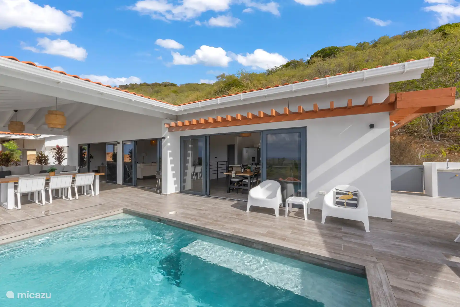 Dankzij de grote schuifdeuren loopt de open woonkamer naadloos over in dit buitengedeelte, wat zorgt voor de ultieme Caribische leefervaring. 