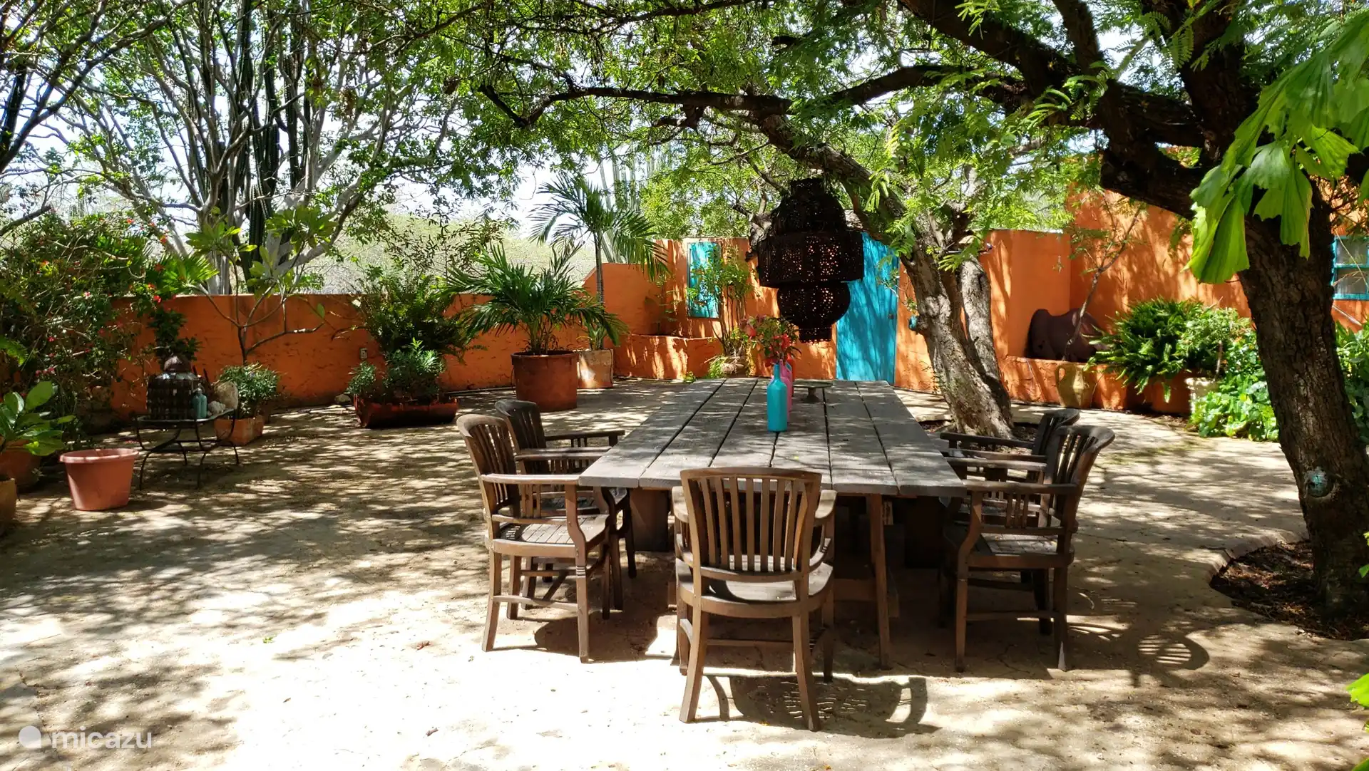 Esta mesa de comedor en el jardín a la sombra de los árboles es ideal para una barbacoa o un desayuno tranquilo.