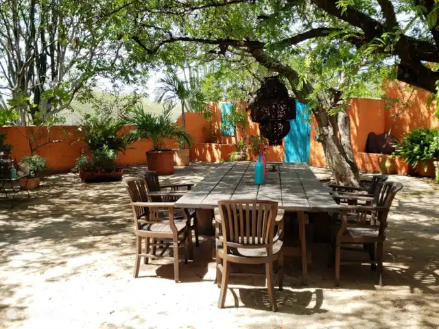 geschakelde woning huren in Aruba, Centraal Aruba, Savaneta – Natural Paradise Guesthouse Deze dinertafel in de door bomen overschaduwde tuin is heerlijk voor barbecue of een ontspannen ontbijt.