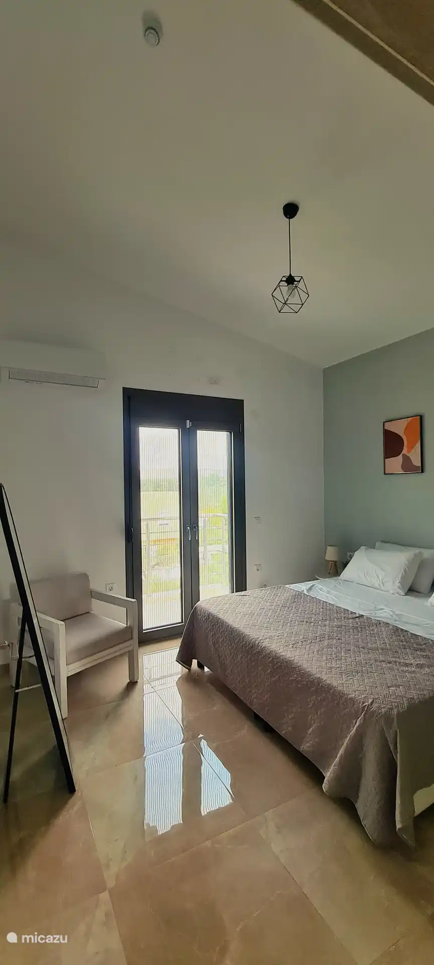 Habitación moderna con una cama grande y cómoda, aire acondicionado y balcón privado: la combinación perfecta de comodidad y aire fresco para una estadía tranquila.