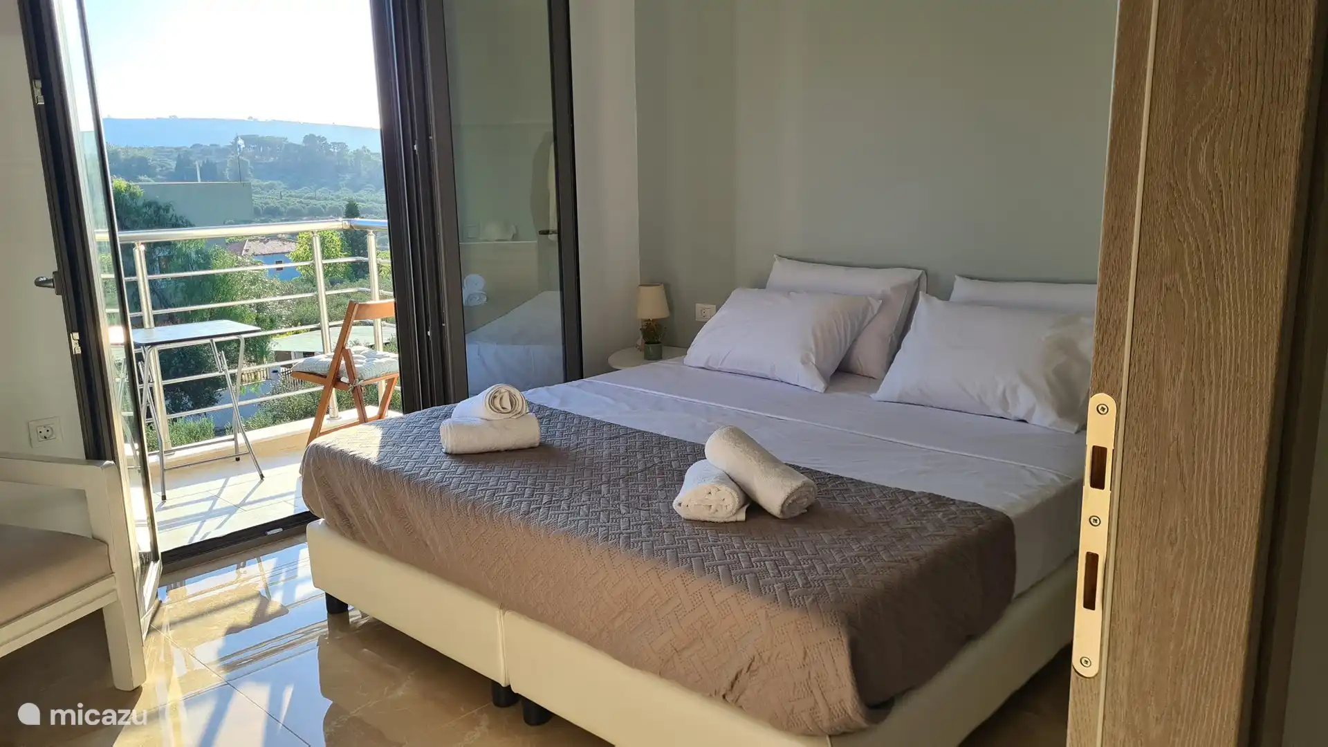 Dormitorio luminoso y acogedor con cama doble, aire acondicionado y acceso directo a un balcón privado con una vista increíble. Ideal para relajarse después de un día de exploración.