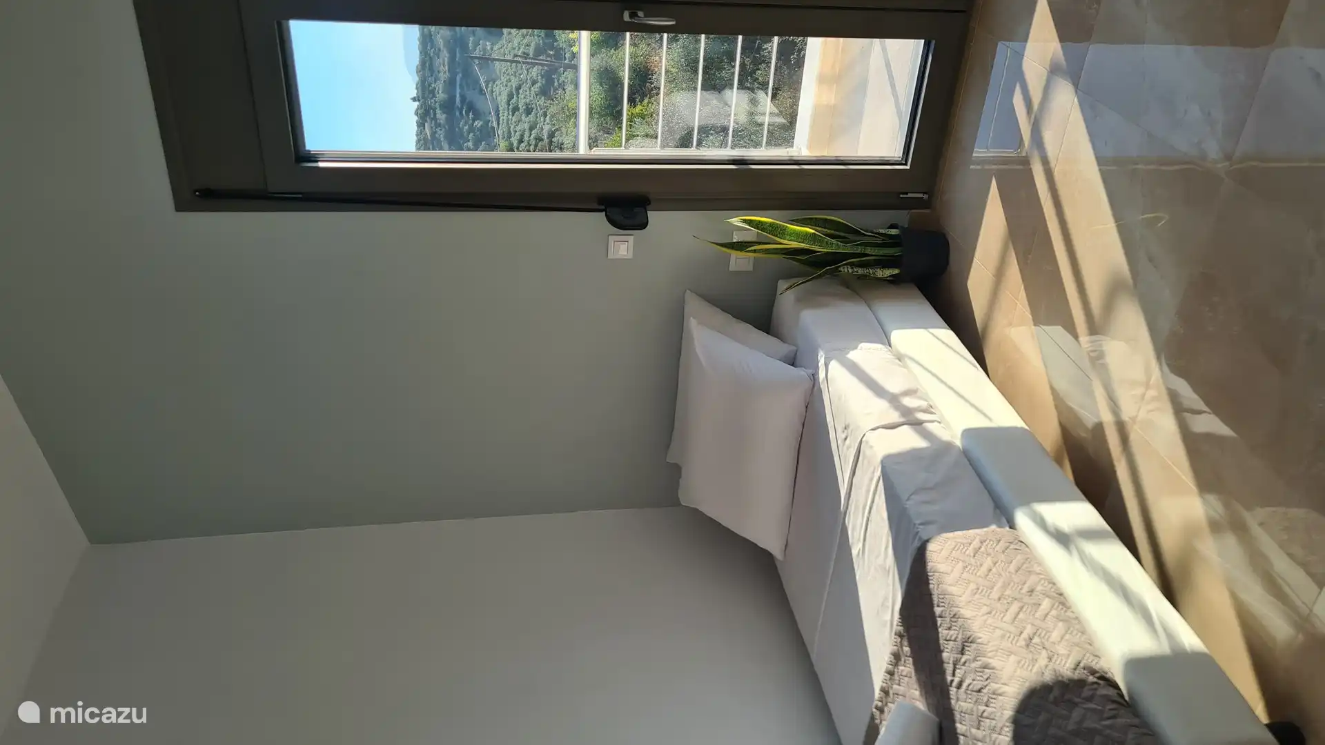 Dormitorio luminoso y acogedor con una cómoda cama, aire acondicionado y acceso directo a un balcón privado con una vista increíble.