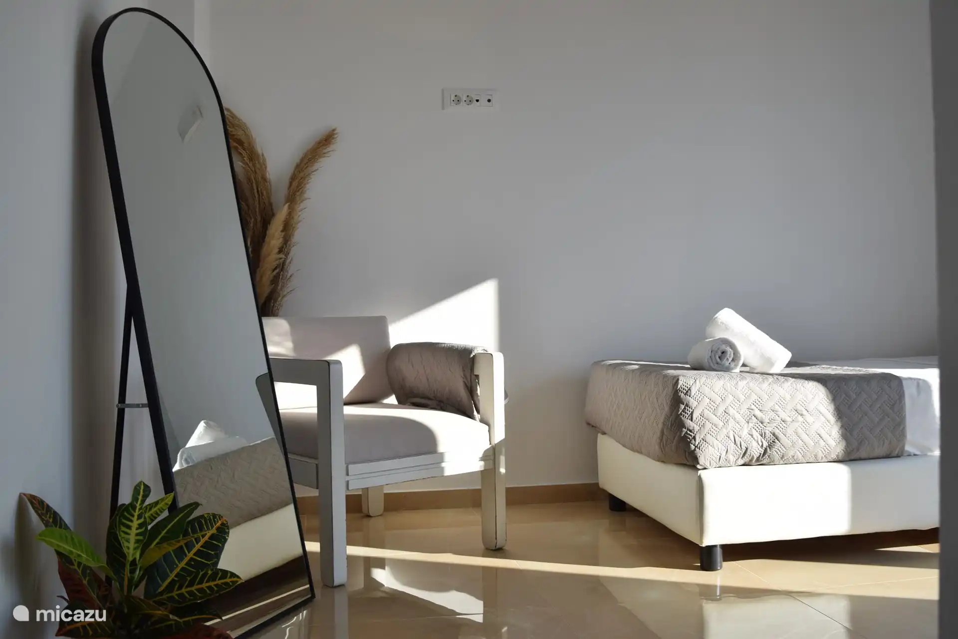 Dormitorio luminoso y acogedor con una cómoda cama, aire acondicionado y acceso directo a un balcón privado con una vista increíble.