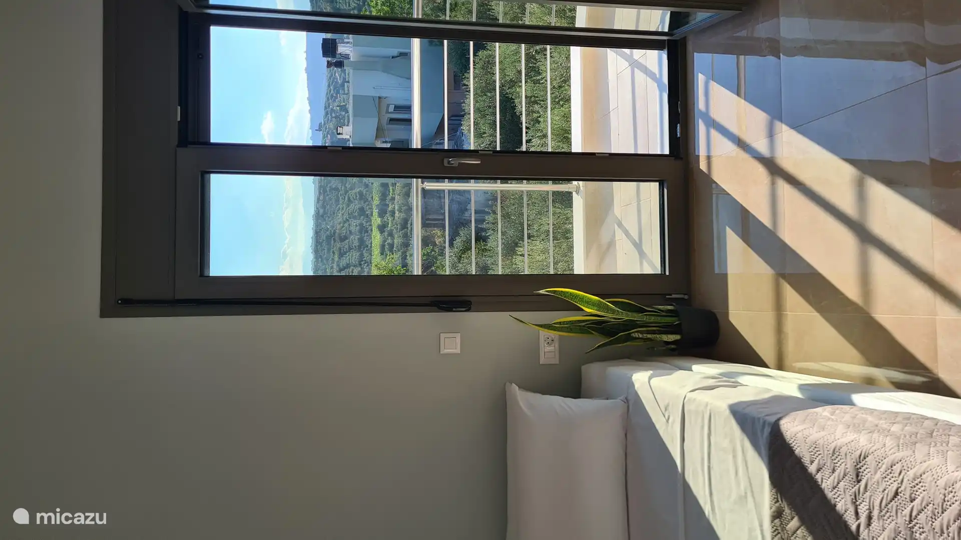 Dormitorio moderno con un diseño minimalista, realzado por la presencia tranquilizadora de plantas de interior: un espacio sereno y elegante para descansar y recargar energías.