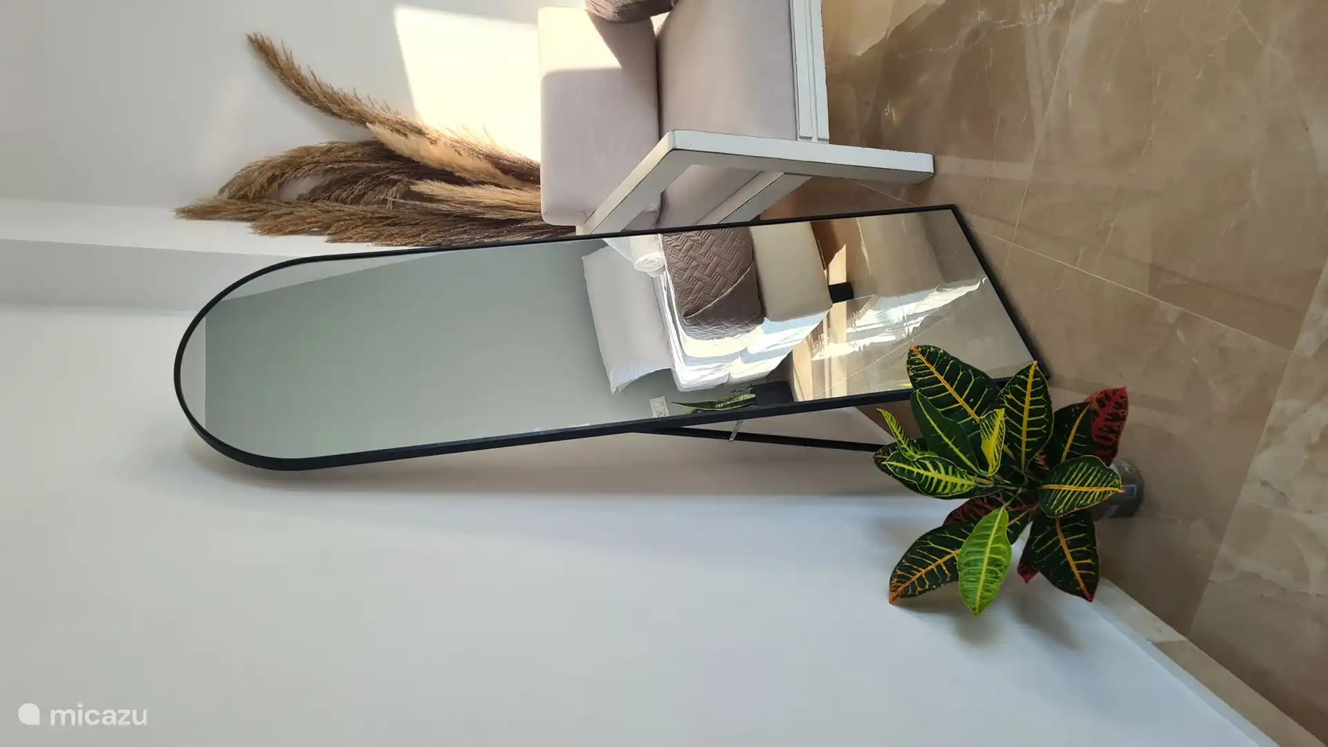 Dormitorio moderno con un diseño minimalista, realzado por la presencia tranquilizadora de plantas de interior: un espacio sereno y elegante para descansar y recargar energías.