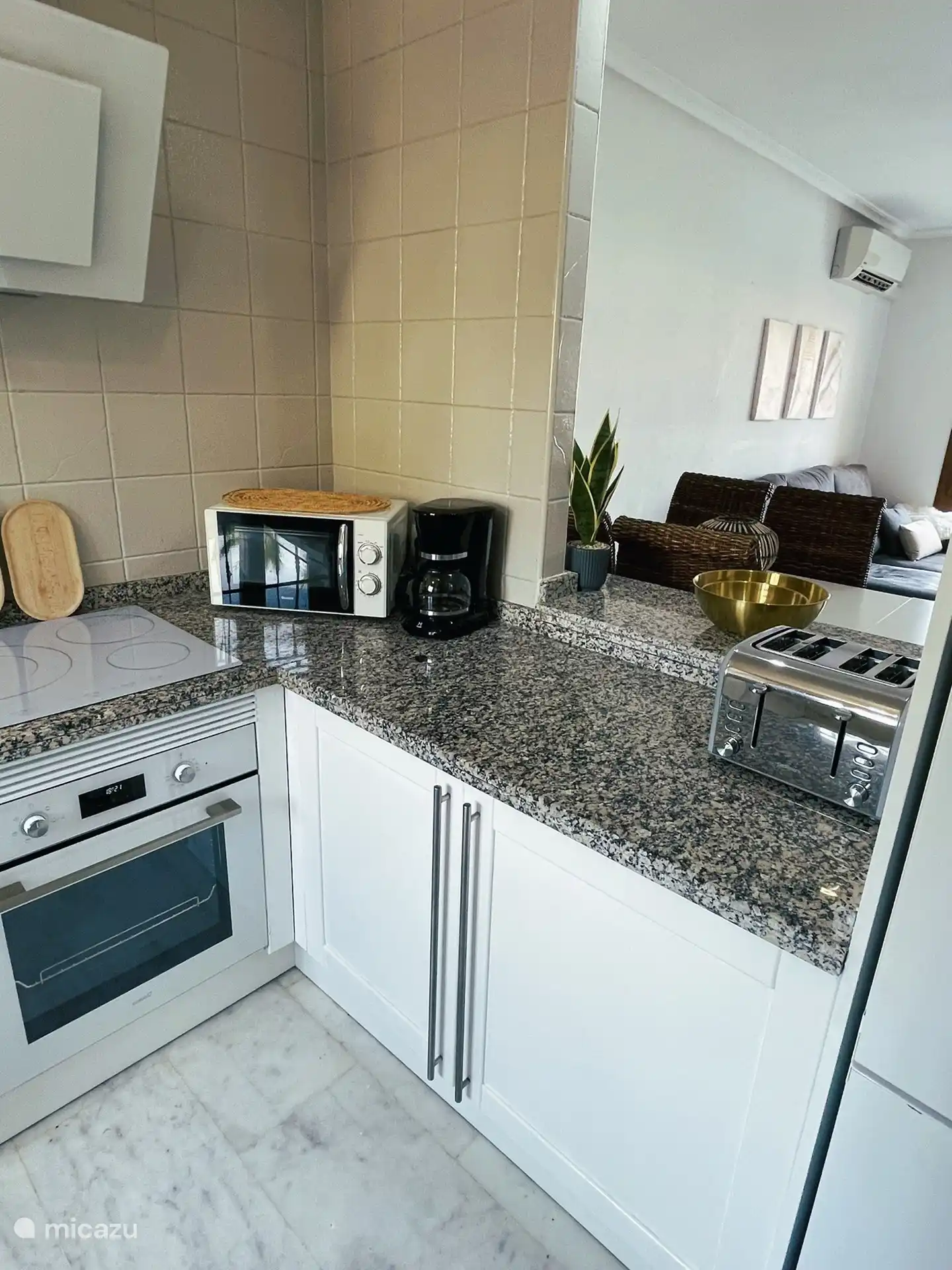 Ausgestattete Küche mit neuen Geräten wie Backofen, Induktionskochfeld und Dunstabzugshaube