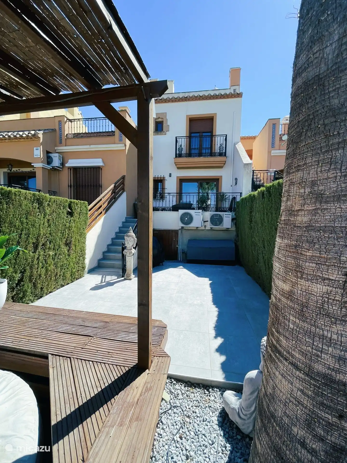 Von der Pergola aus der Blick auf die hintere Fassade und die Terrasse vom Wohnzimmer aus