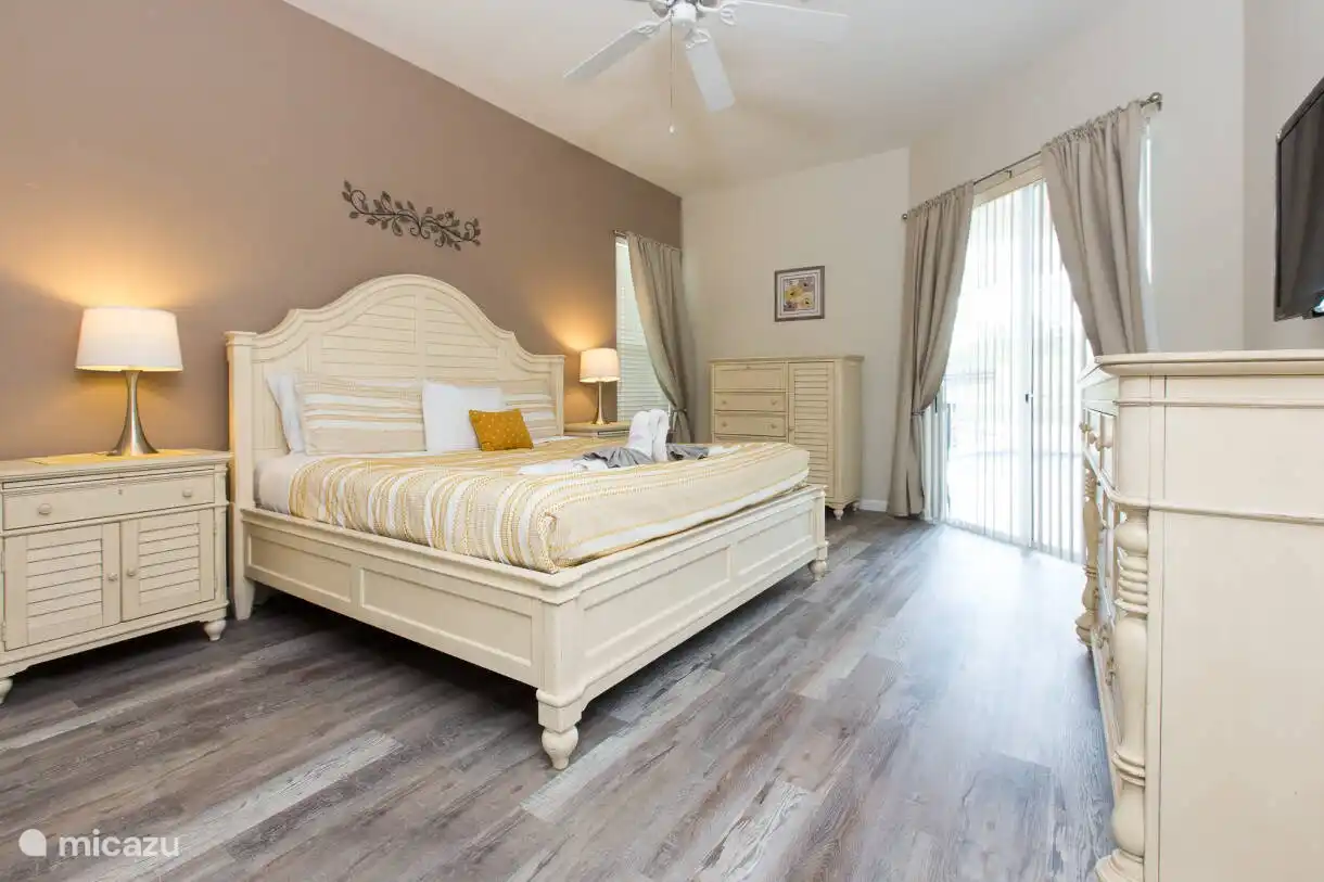 Hauptschlafzimmer mit Kingsize-Bett und Zugang zum Pooldeck