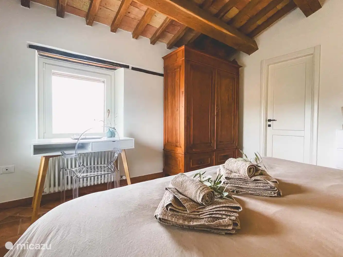 Schlafzimmer (3) mit Doppel-Boxspringbett, Klimaanlage und angrenzendem Badezimmer in der Casa. Das Badezimmer verfügt über eine Toilette, ein Bidet, ein Waschbecken und eine Dusche. Im Zimmer finden Sie einen großen Holzschrank, eine Kommode und einen Schreibtisch mit schönem Blick über die Hügel. 