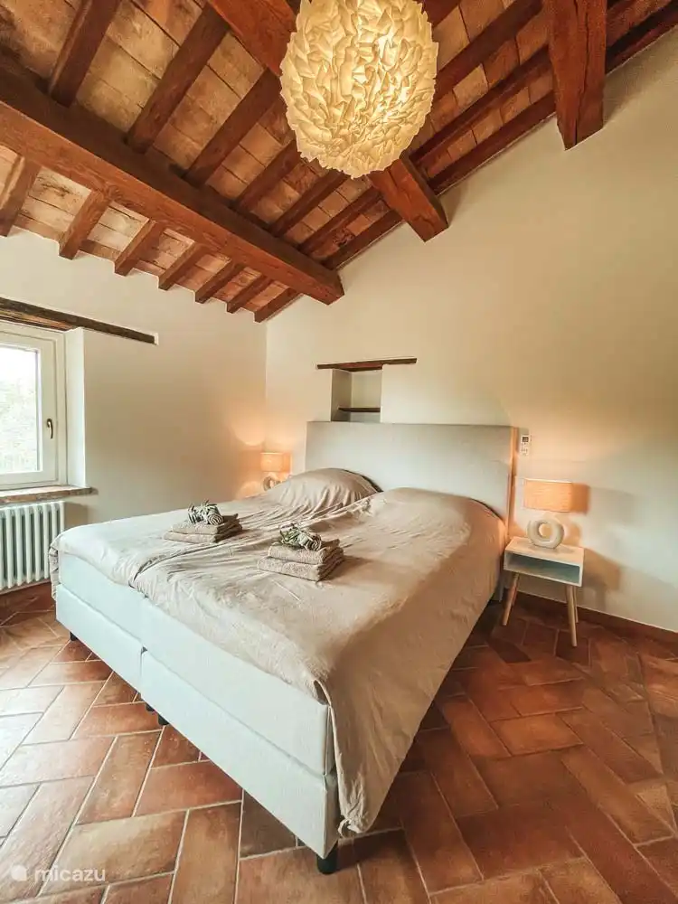 Schlafzimmer (1) in der Casa mit Doppel-Boxspringbett, Klimaanlage, Kleiderschrank für Kleidung und Stuhl. 