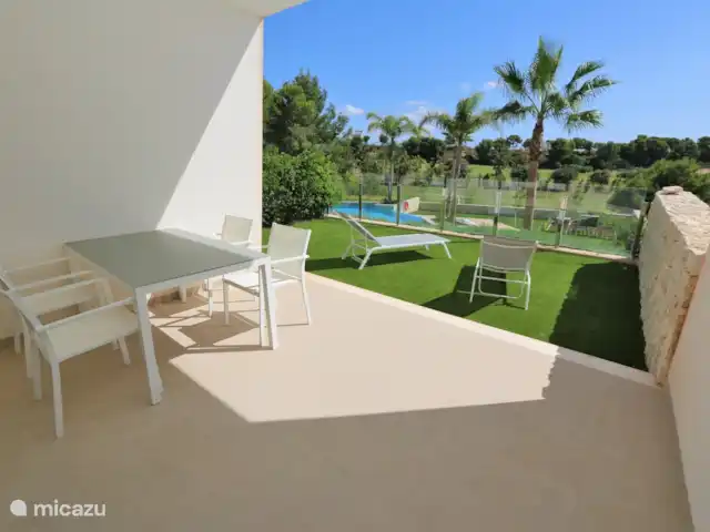 Vue panoramique du golf | Espagne, Costa Blanca, Pilar de la Horadada - appartement La terrasse intérieure avec table de jardin et la terrasse verte avec chaises longues.