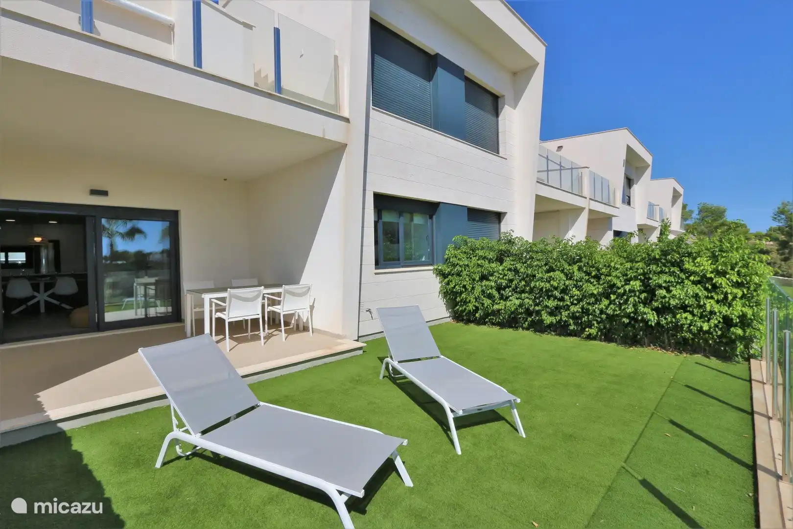 Die Liegewiese mit Liegestühlen am Haus.