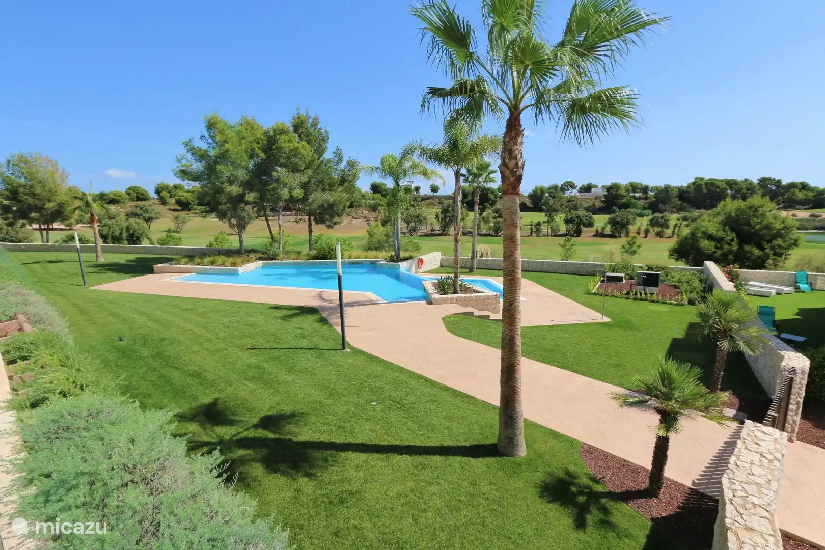 Zugang und Übersicht über den Gemeinschaftspool mit gemeinschaftlicher Liegewiese.