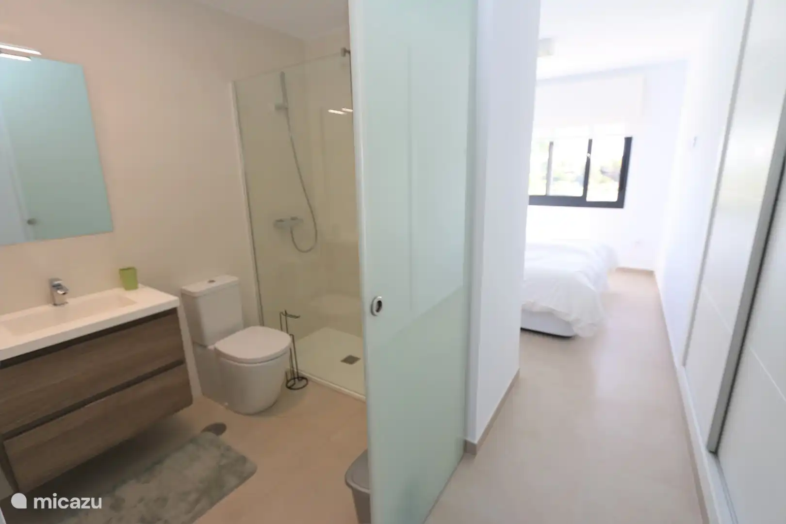 Eines der beiden Badezimmer mit geräumiger begehbarer Dusche, WC und Waschbecken.