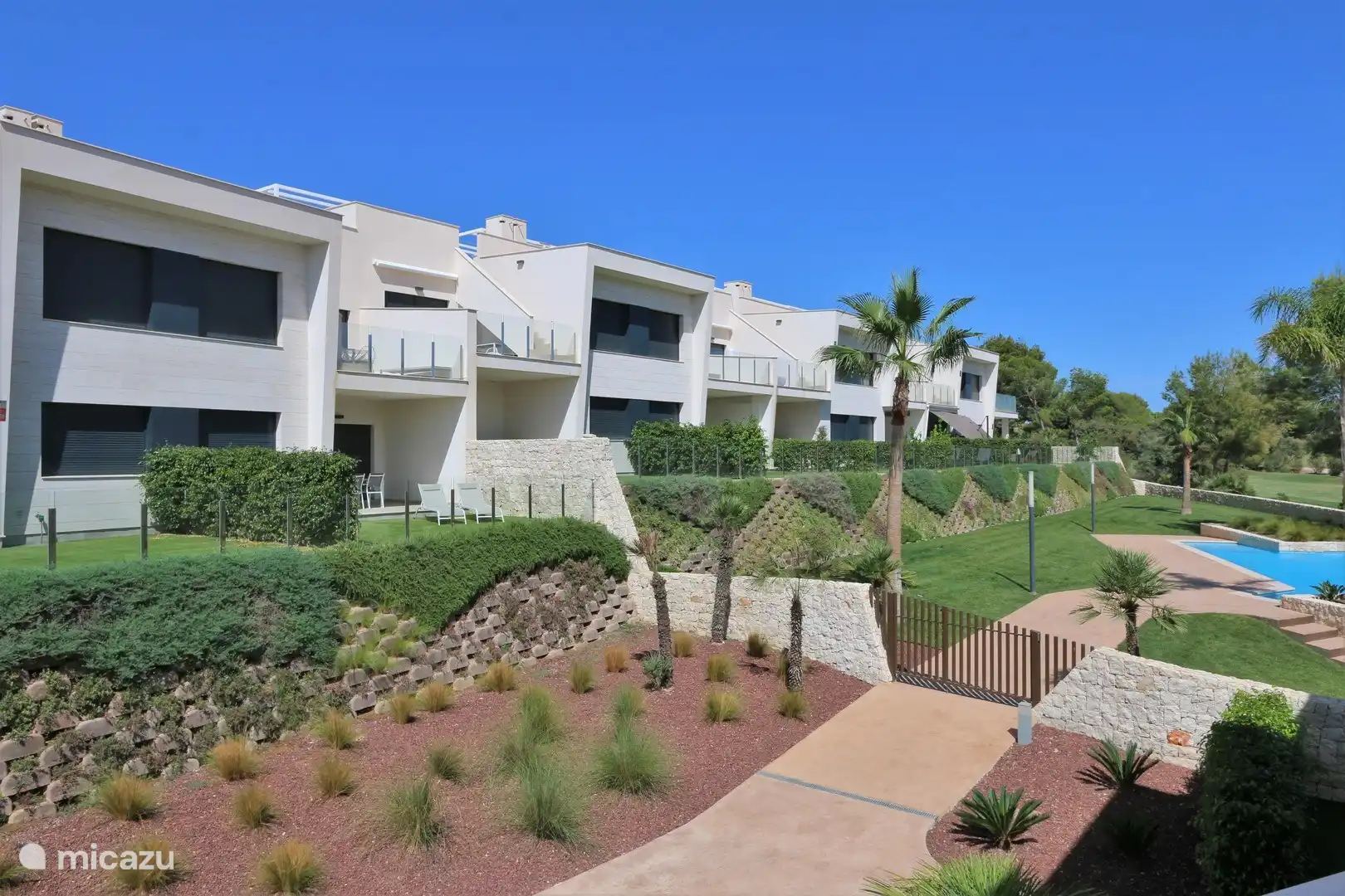 Blick auf die Fassade der Rückseite mit den privaten Gärten und Terrassen.