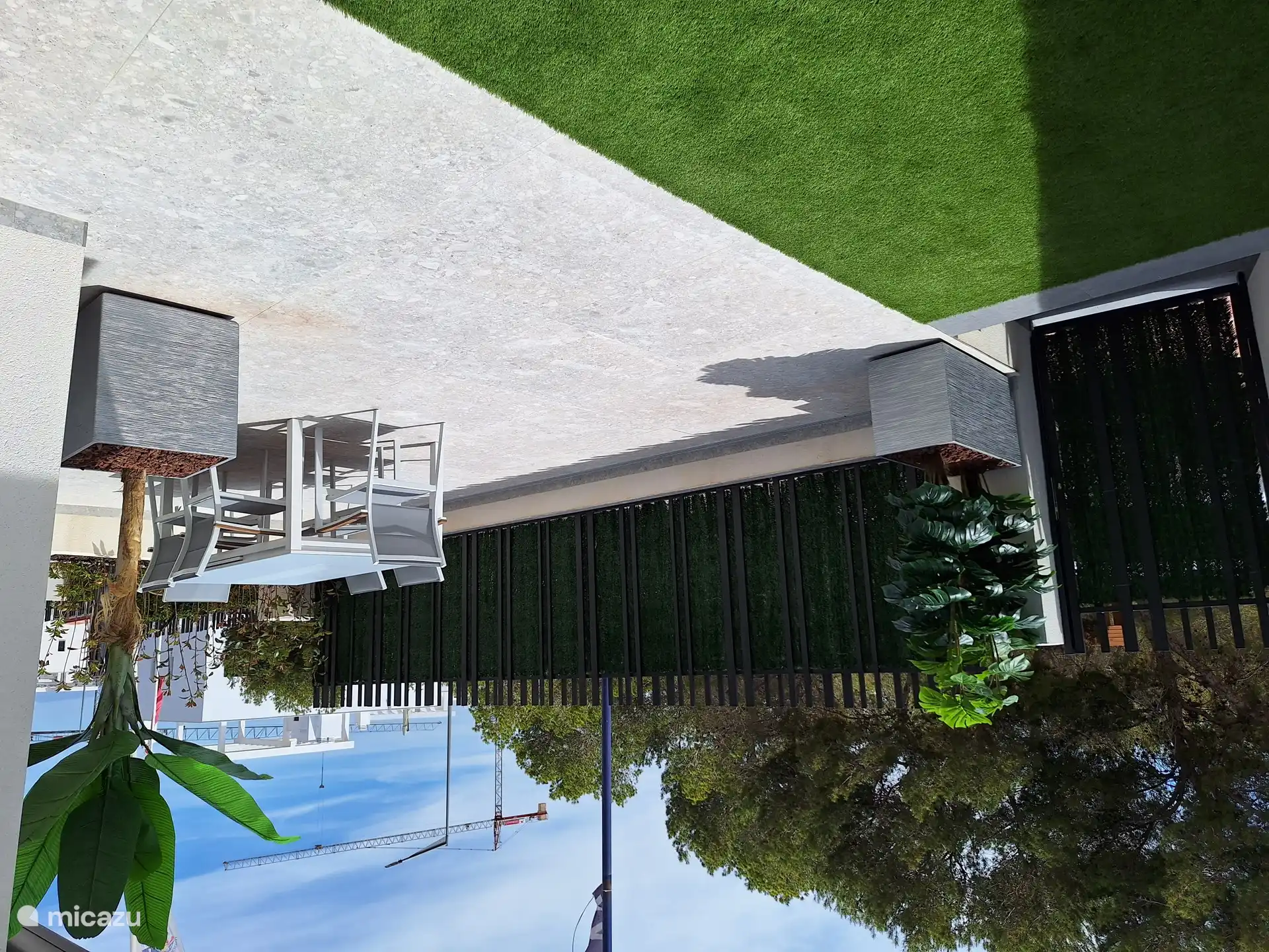 Seitenansicht der vorderen Terrasse. Privatsphäre ist garantiert / kein Blick von der Straßenseite. Auf der linken Seite befindet sich das Einfahrtstor, das sich direkt zur Straße hin öffnet, und der Parkplatz für das Auto.  