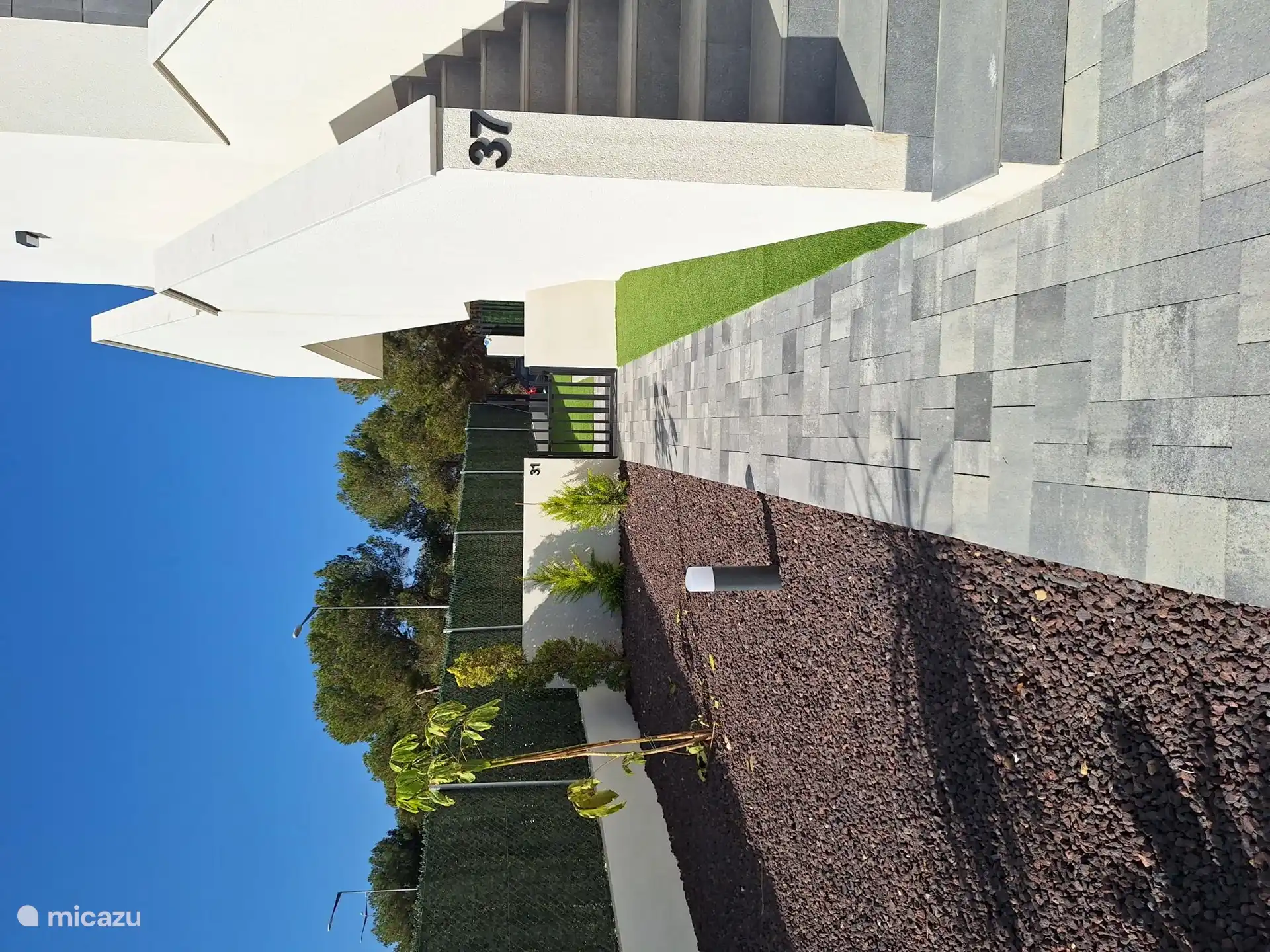 Gehweg von der vorderen/seitlichen Terrasse zur hinteren Terrasse, den Swimmingpools und dem Rest des Komplexes  