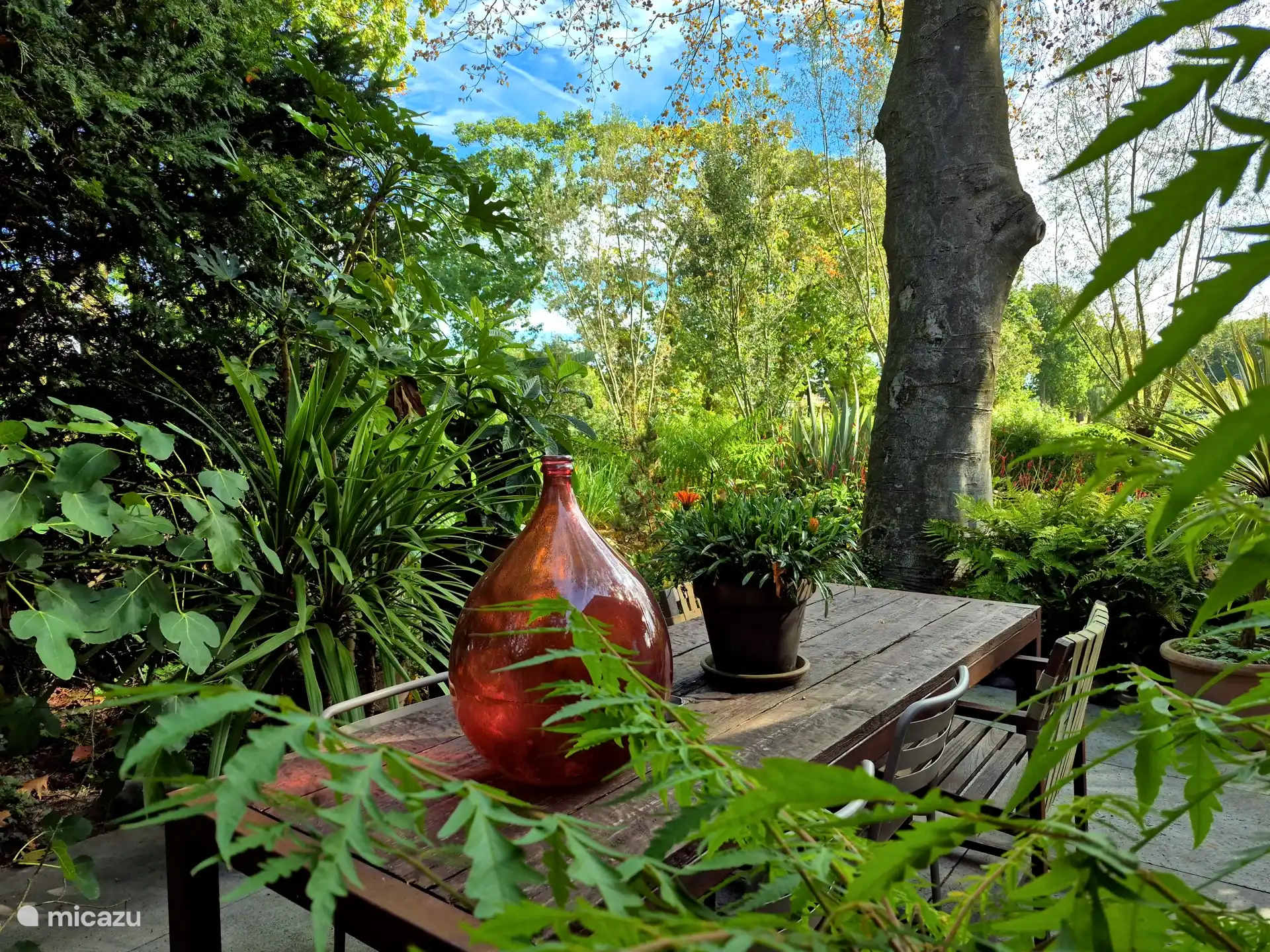 Esstisch mit Stühlen und einem kleinen Egg-BBQ.