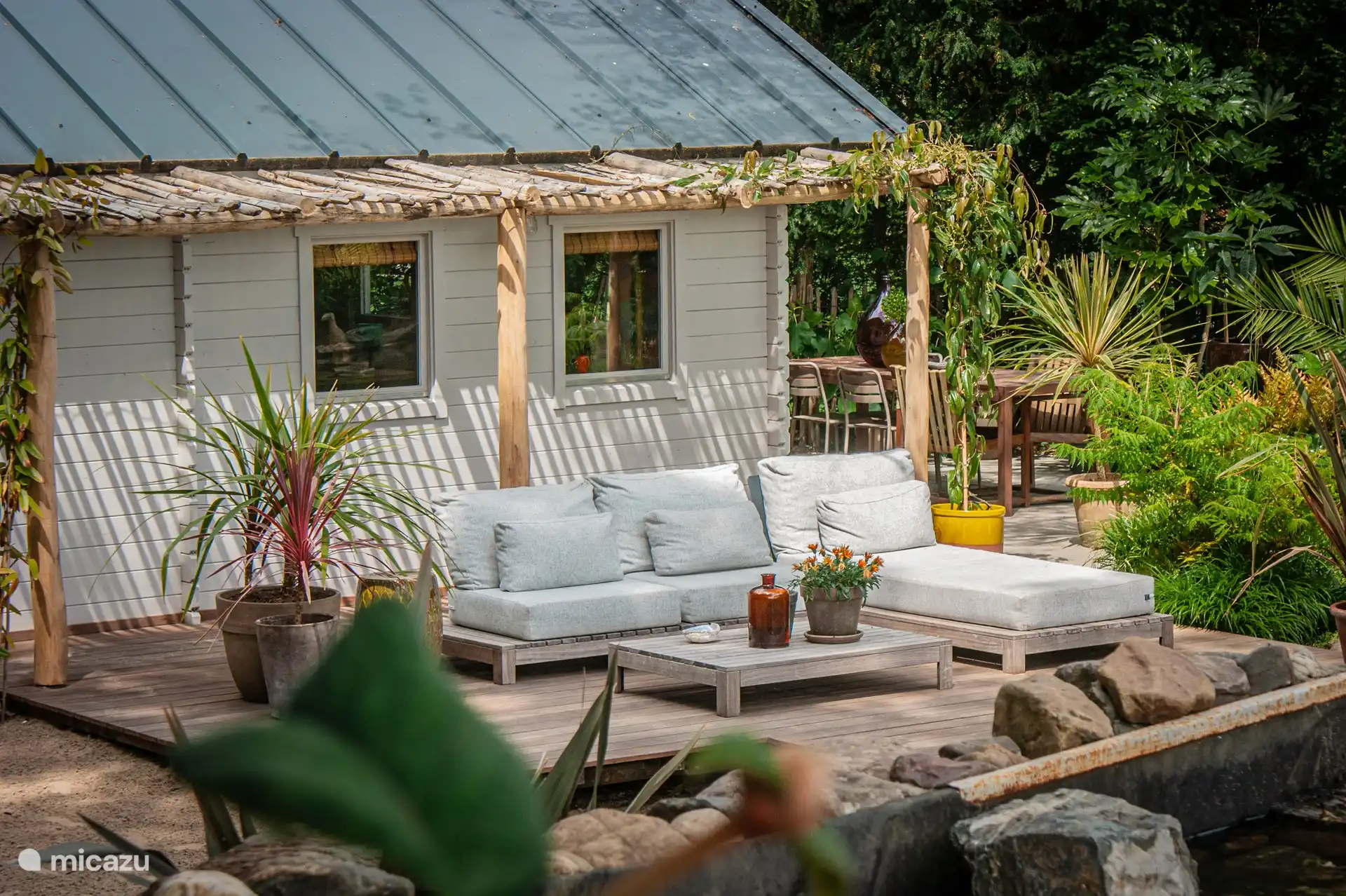 Pergola und Lounge-Set, neben dem Wasser.