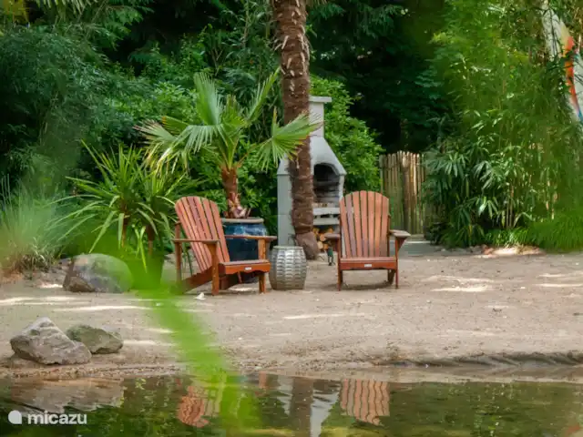 CoCo Cabin en Países Bajos, Utrecht, Woudenberg - casa pequeña  Sillas de playa en la playa con palmeras