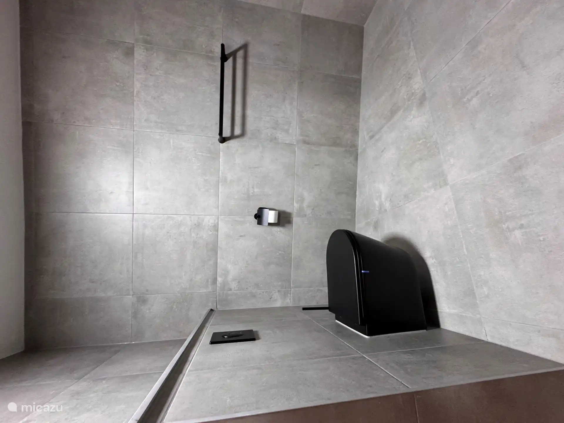 Badezimmer mit Dusche, Waschbecken und WC.