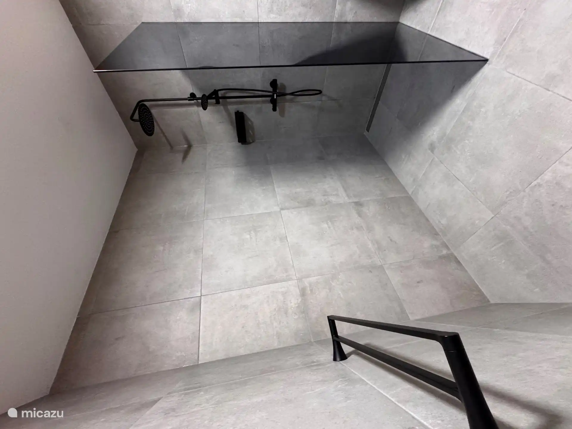 Badezimmer mit Dusche, Waschbecken und WC.