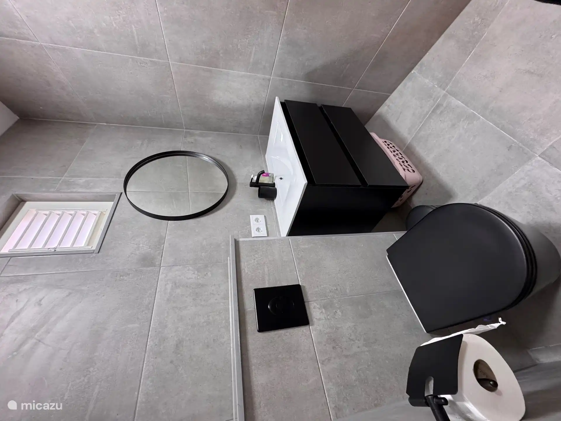 Badezimmer mit Dusche, Waschbecken und WC.