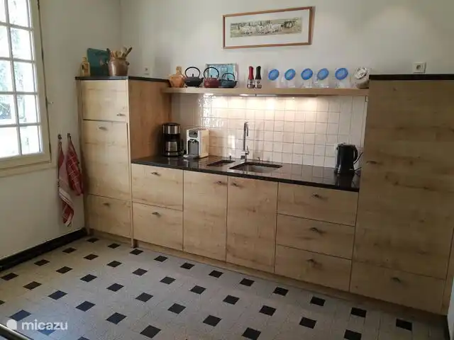 Kitchenette with dishwasher, refrigerator, coffee machine and kettle.