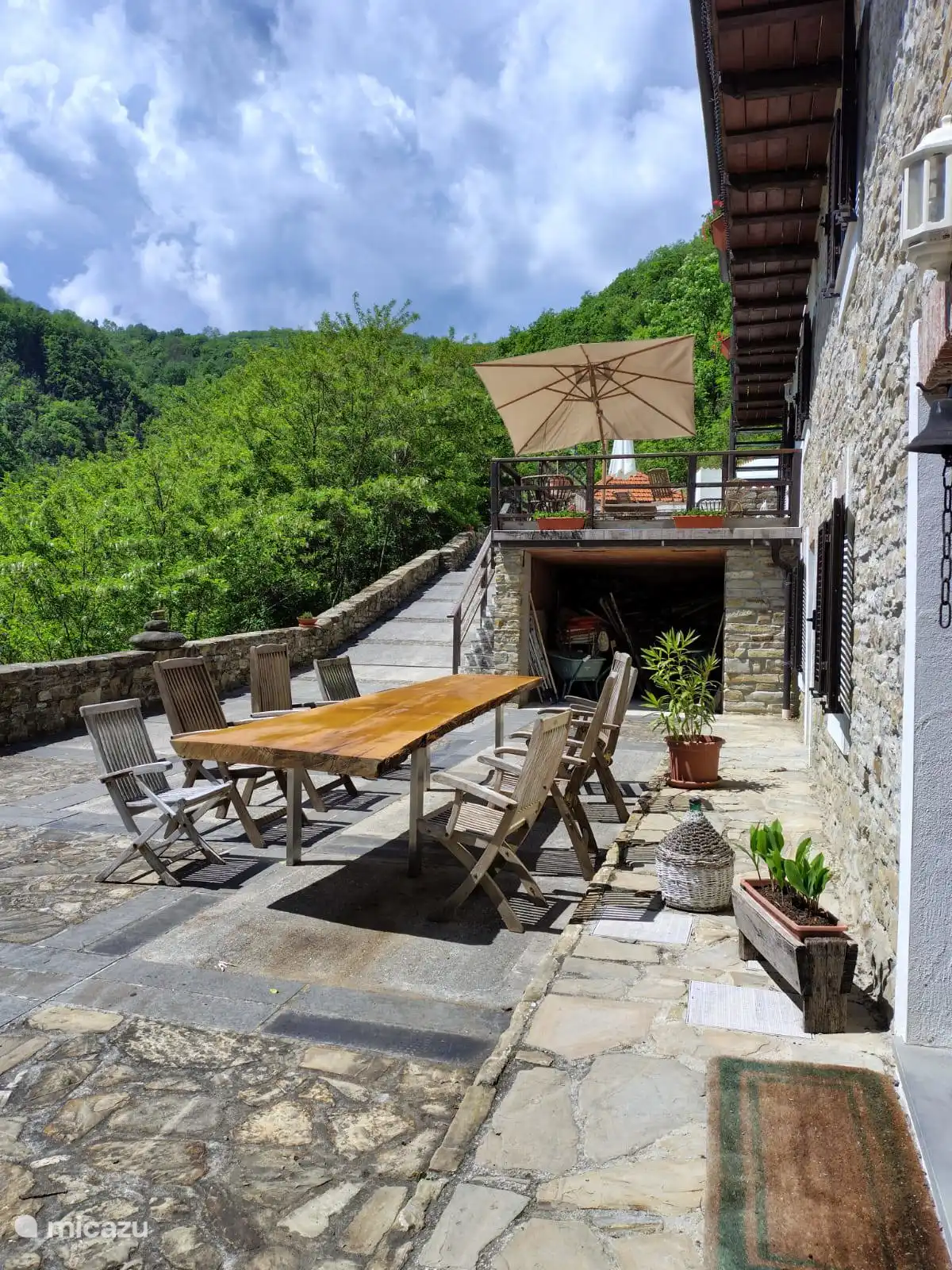 Terrasse mit Esstisch und dahinter die zweite Terrasse