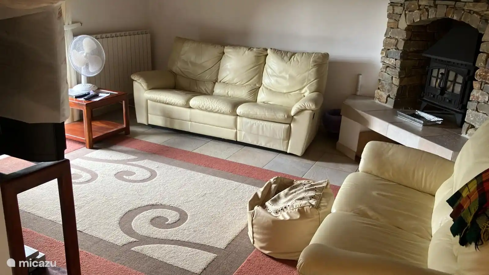 Wohnzimmer mit französischen Türen zum Balkon und Kamin.