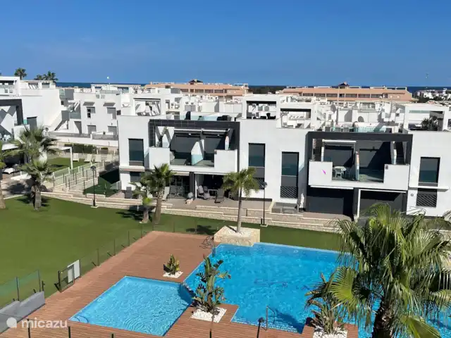 Penthouse Casa Isabella | Espagne, Costa Blanca, Torrevieja - appartement Vue sur la mer, le jardin et la piscine depuis la terrasse sur le toit.
Sur le côté gauche de la piscine se trouve la piscine pour enfants peu profonde et séparée.