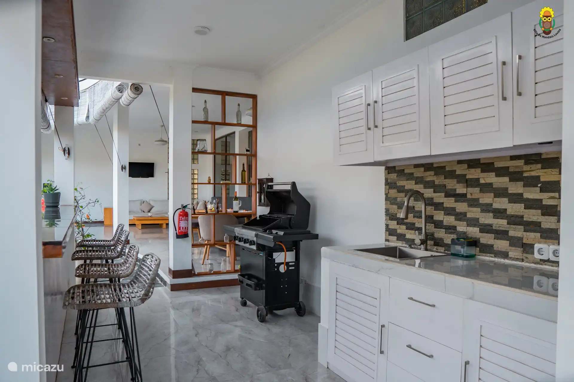 Outdoor kitchen with a bbq. You can also enjoy the relaxing view at the bar. 