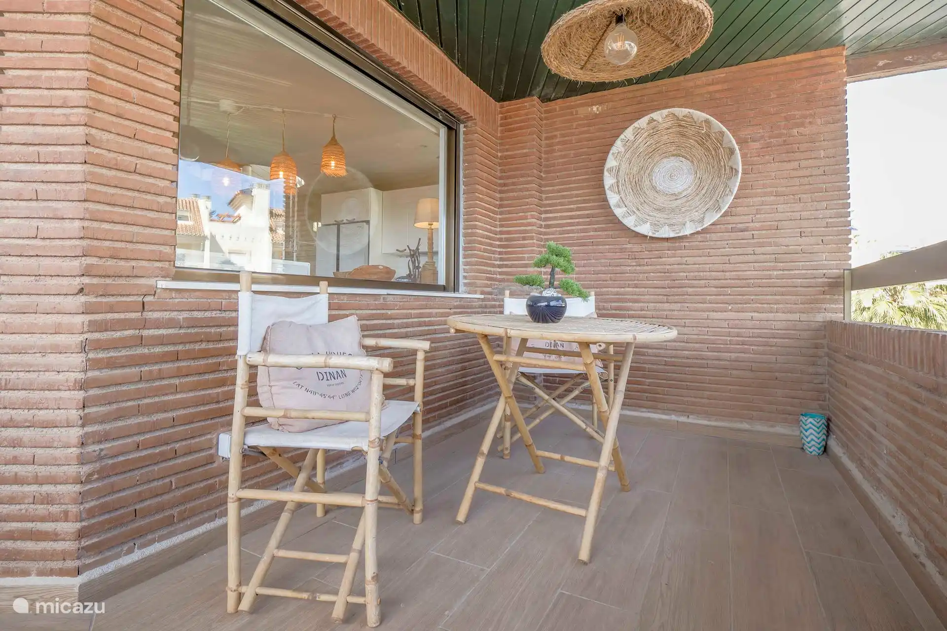 Überdachte Terrasse mit Meerblick auf den Strand und die Promenade von Plya Arenal.