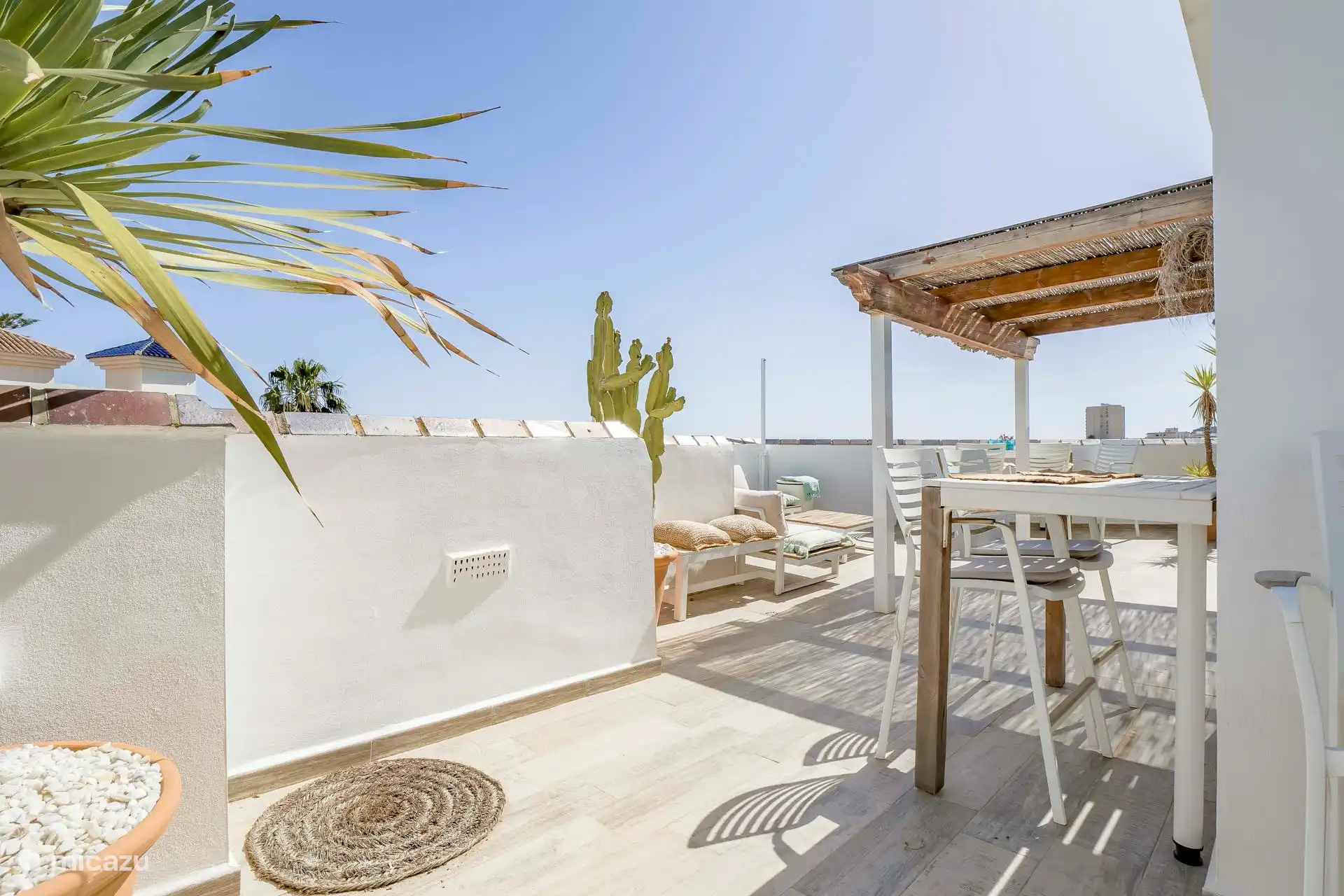 Verschiedene Sitzgelegenheiten für die schwülen Sommerabende auf dieser Terrasse mit Meerblick