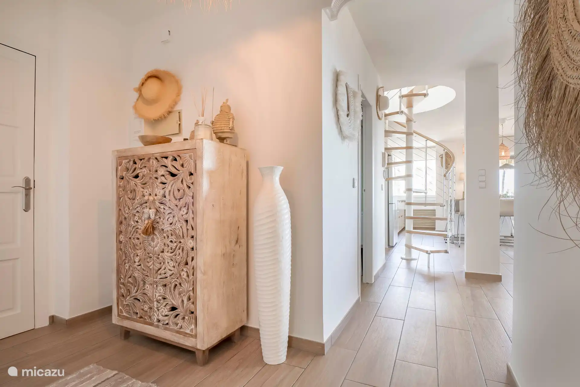 Über die Wendeltreppe gelangt man auf die großzügige Dachterrasse mit Meerblick. 