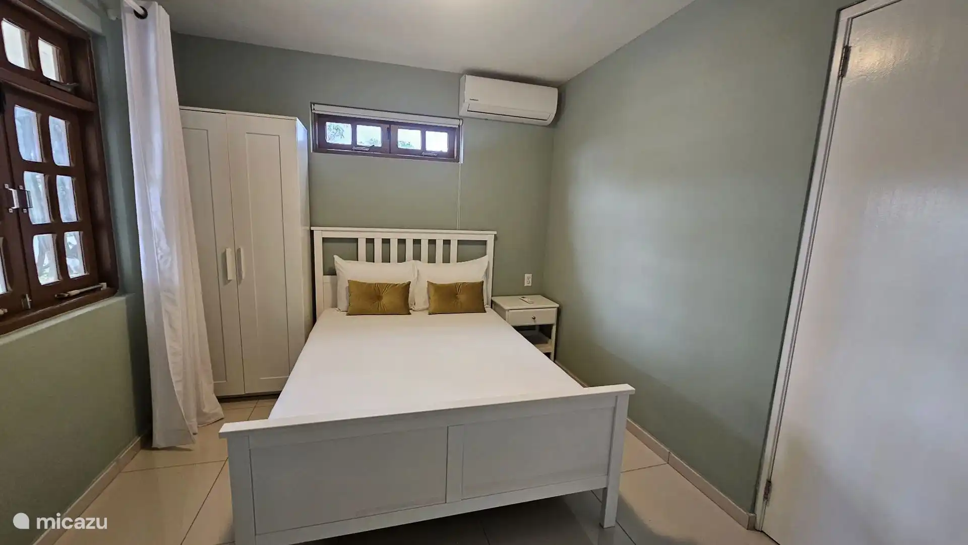 Slaapkamer met queen size bed op de begane grond. 