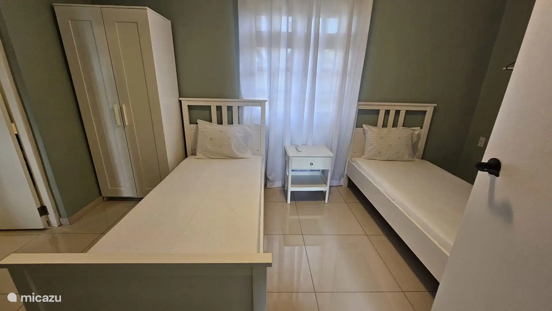 slaapkamer voorzien van twee enkelbedden 