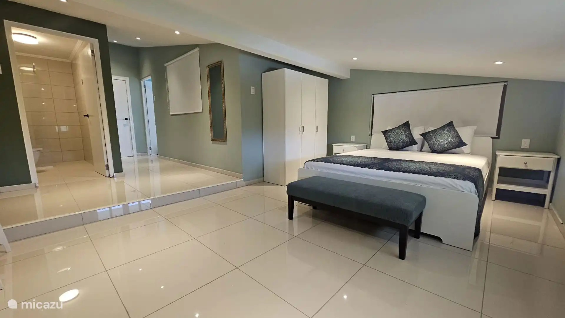 Hoofdslaapkamer met kingsize bed, eigen tv, bureau en badkamer. 