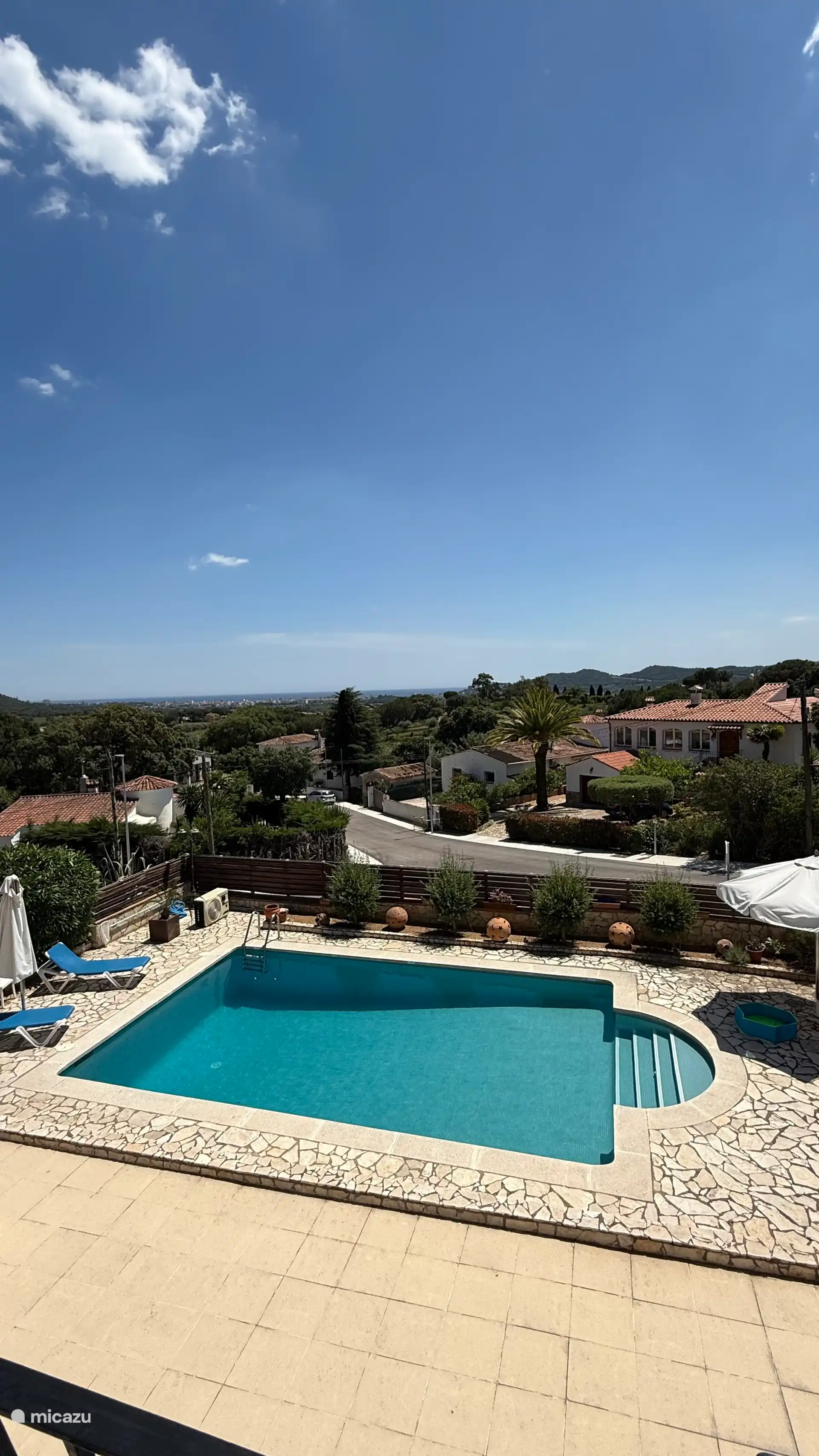 Atemberaubender Ausblick auf das Meer in der Ferne und das Grün der Hügel.