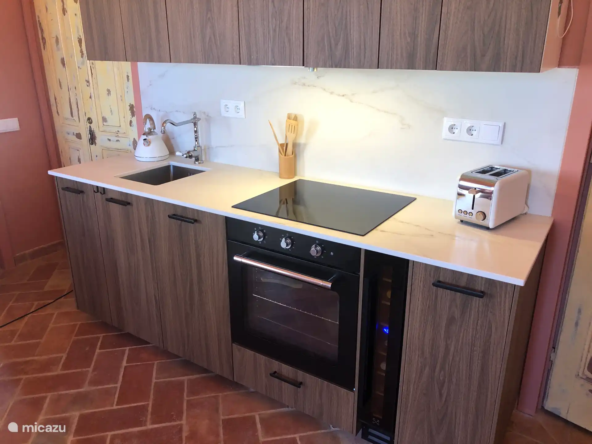 Küche der Casa Pauline mit Ofen, Weinkühlschrank und Geschirrspülmaschine