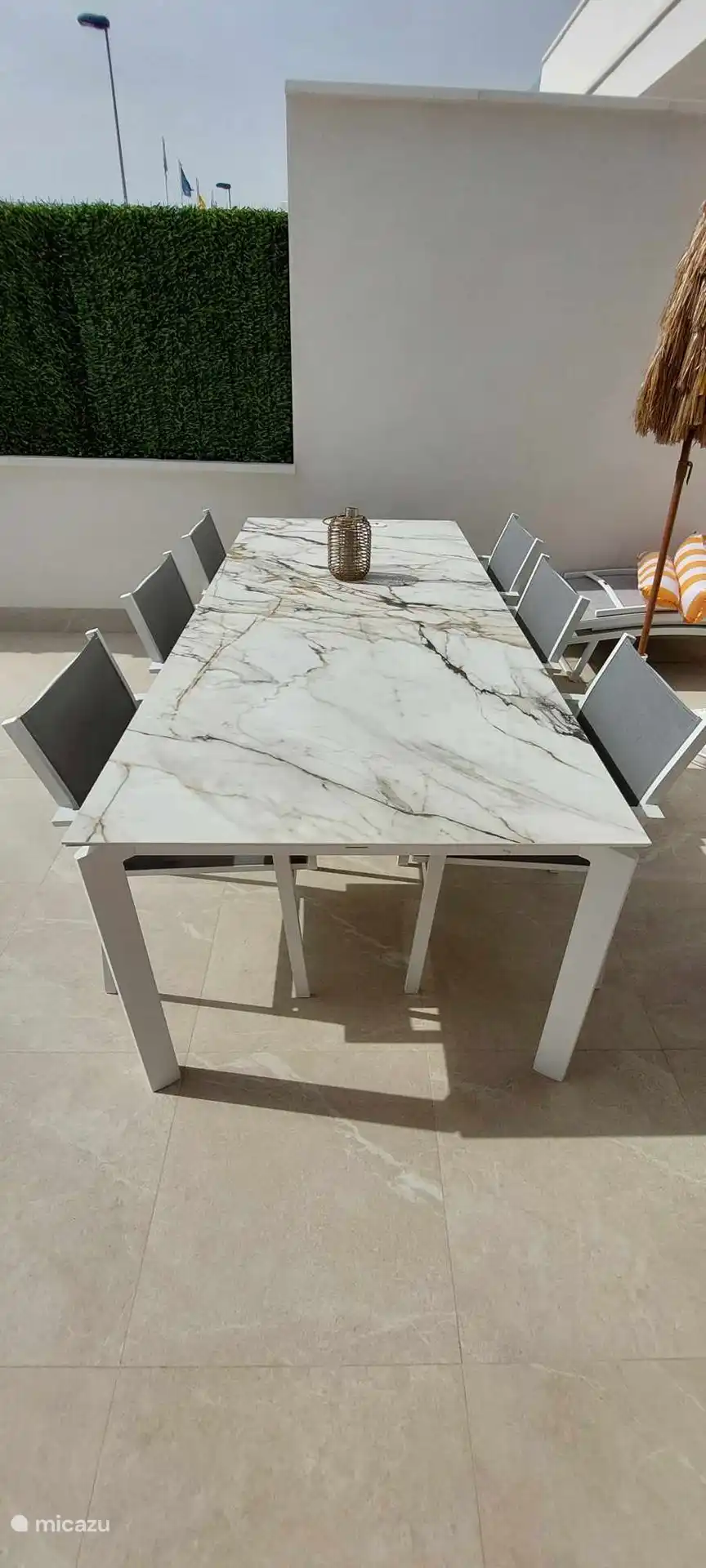 Hermosa mesa de cerámica con capacidad para 8 personas en la terraza delantera junto a la piscina