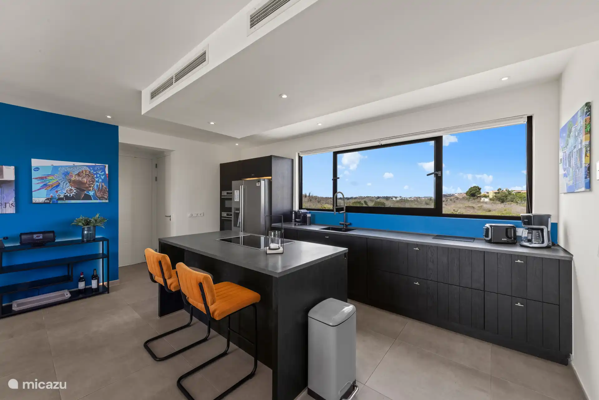 De open keuken is voorzien van een side-by-side koelkast en moderne apparatuur.