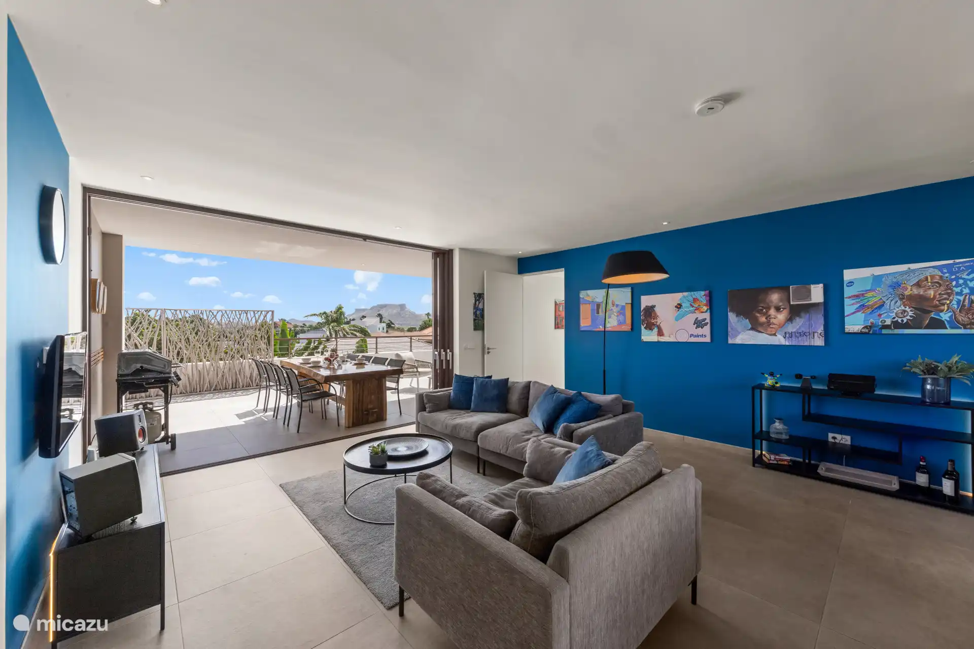 Ruime woonkamer met TV en muzieksysteem.